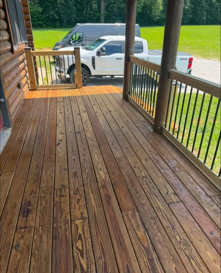 New porch decking and matching rail under roof — refinished board by board and sealed against the weather.